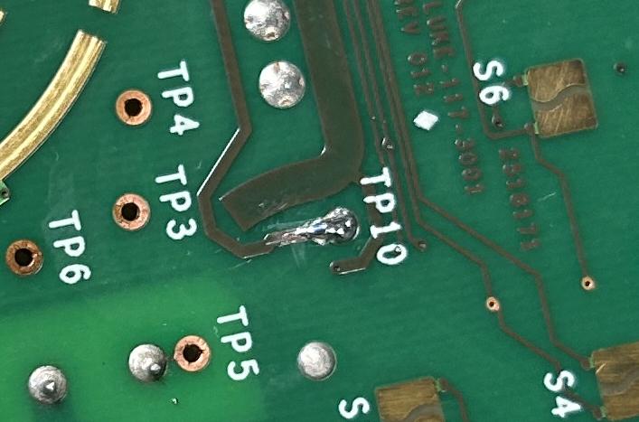TP10 after the repair, with solder bridging the trace to the via