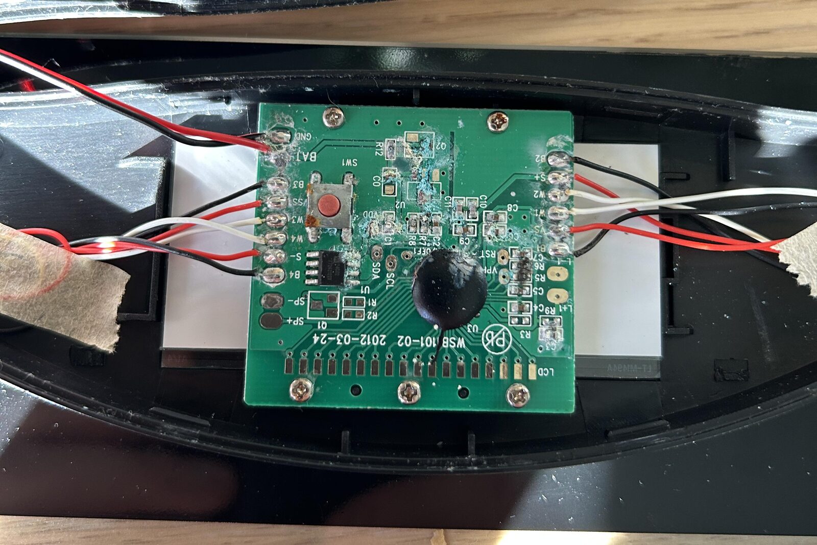 Circuit board of a water-damaged bathroom scale, with dried residue and oxidation